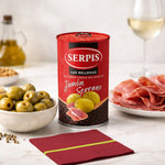 Serpis can of stuffed olives with a plate of cured meat and bowl of olives on a table.