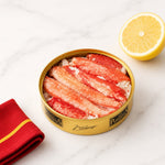 Can of snow crab Los Peperetes with a lemon and red napkin on a white surface