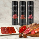Three Fermin sausages packages with sliced sausages on a wooden background