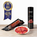 Fermin Iberico salami with packaging and a plate of sliced salami on a wooden surface, featuring the International Taste Institute award.