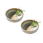 Two ceramic bowls with a decorative pattern and green leaves on a white background