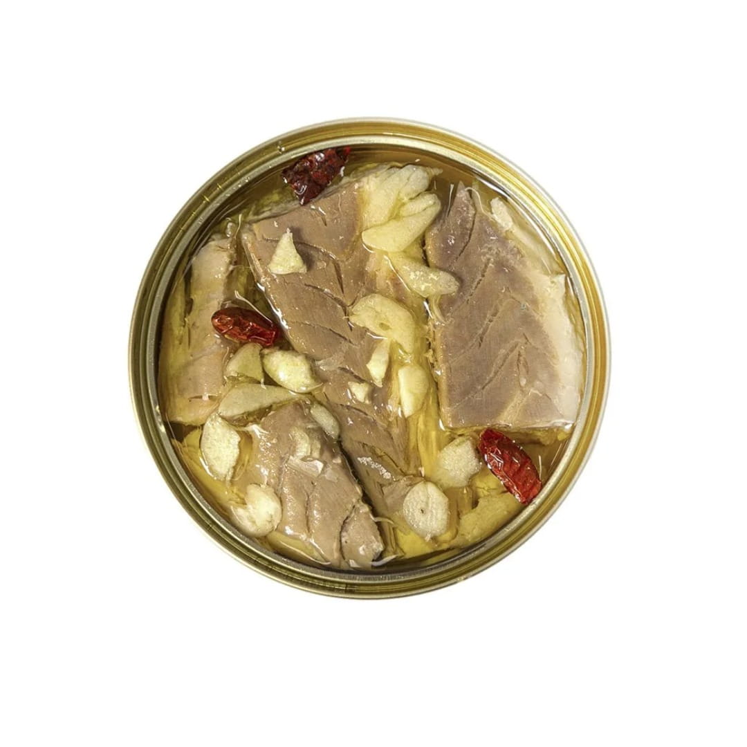 Canned seabass with garlic and cayenne on a white background