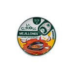 Tin of 'La Curiosa' Mejillones in garlic oil with colorful label on a white background