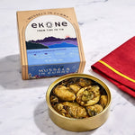 Tin of mussels in curry with Ekone packaging on a marble surface