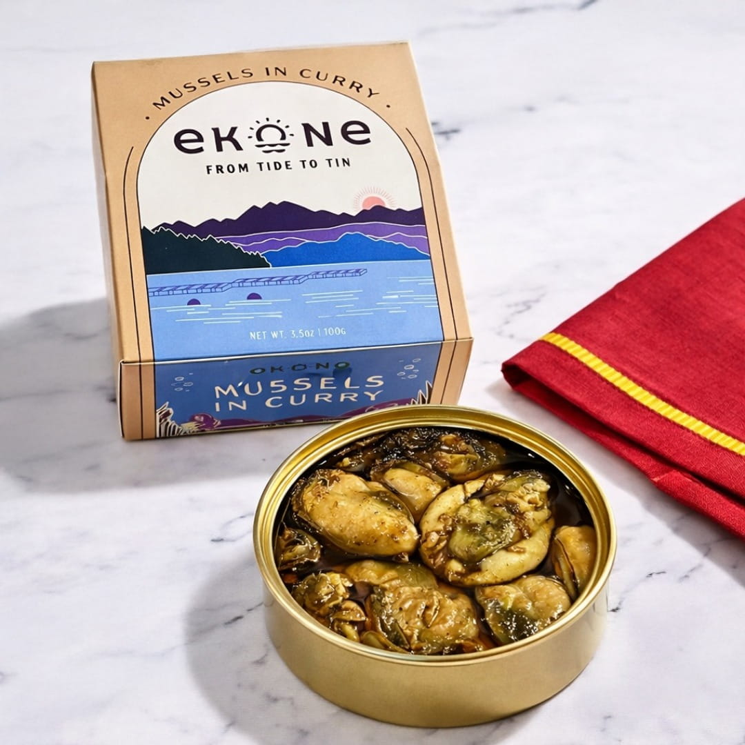 Tin of mussels in curry with Ekone packaging on a marble surface