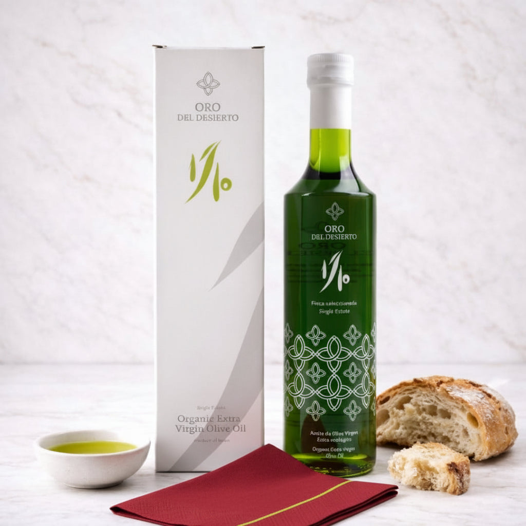 Oro del Desierto extra virgin olive oil bottle with packaging and bread on a white background