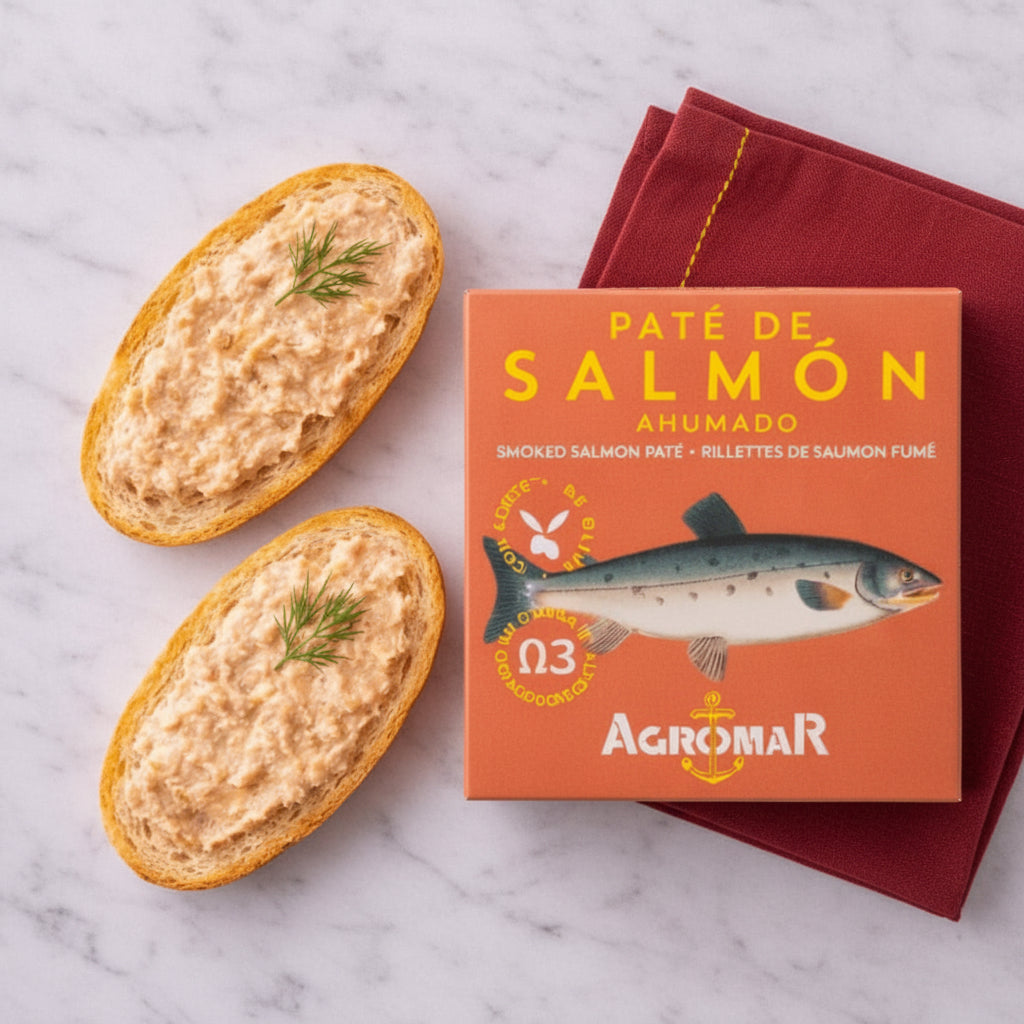 Two slices of bread with smoked salmon pate and a box of Agromar smoked salmon pate on a marble surface.
