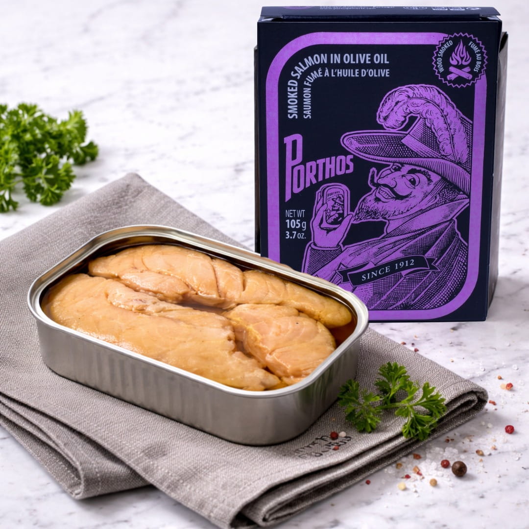 Tin of sliced salamon with a purple Porthos packaging on a white surface.