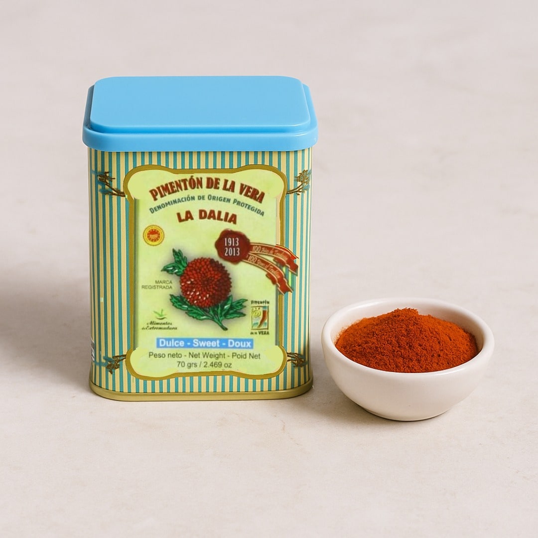 Tin of La Dalia paprika with a small bowl of paprika powder on a light background