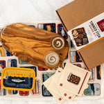 Wooden tinned fish board kit with various components on a white background
