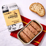Tin of Santa Catarina tuna with ginger with packaging and bread on a red cloth